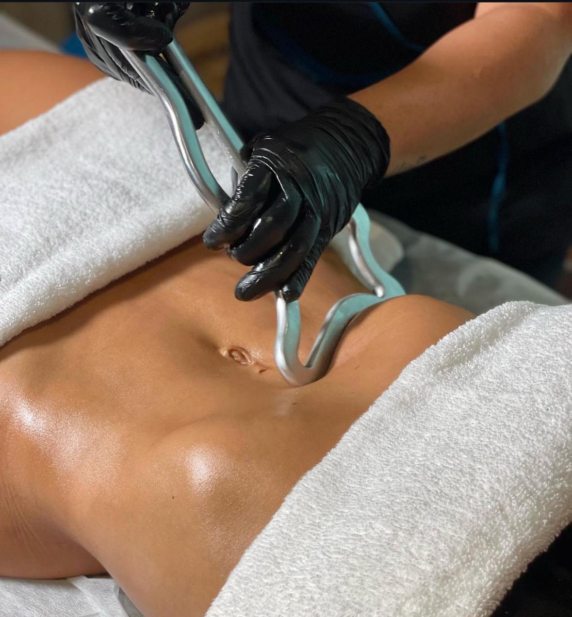 Sesión de metalterapia corporal con instrumentos metálicos aplicados sobre el abdomen
